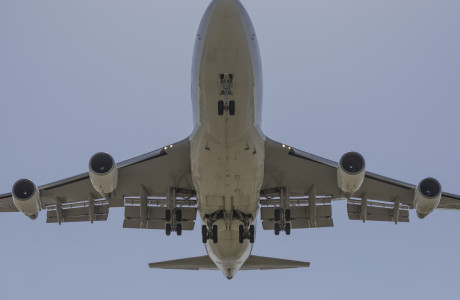 Eine Boeing 747 von unten mit ausgefahrenem Fahrwerk