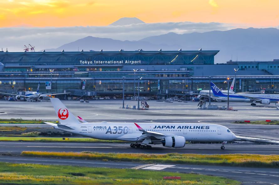 Ein Terminal von Tokio Haneda mit Bergen im Hintergrund.